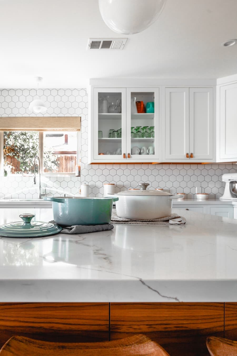 Kitchen with green cabinetry and a white tile splashback